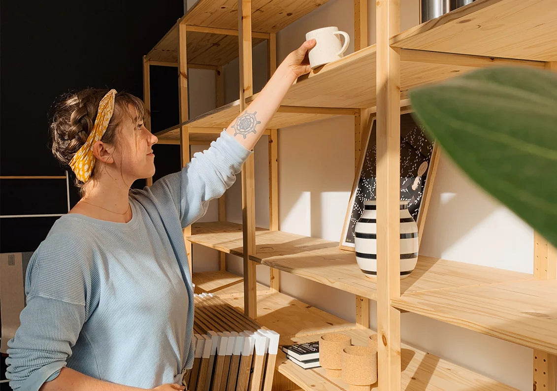 Woodland Mod Store Employee stocking decor on wooden shelves