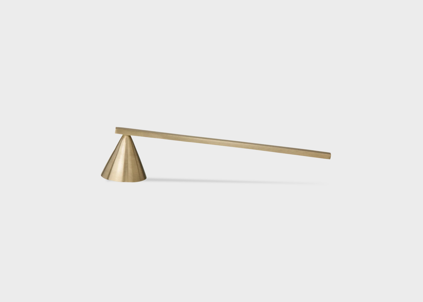 A brass candle extinguisher by Ferm Living with a cone extinguisher and long straight handle as sold by Woodland Mod