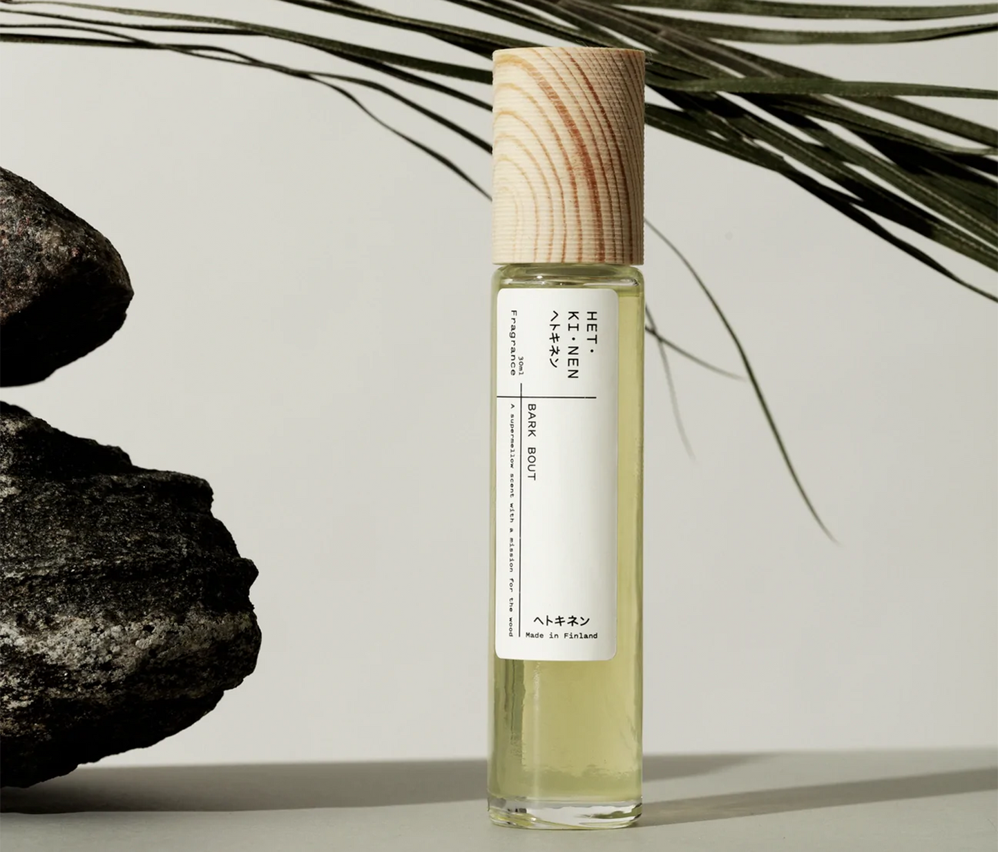 Hetkinen Body Fragrance - Bark Bout against backdrop of rocks and palms