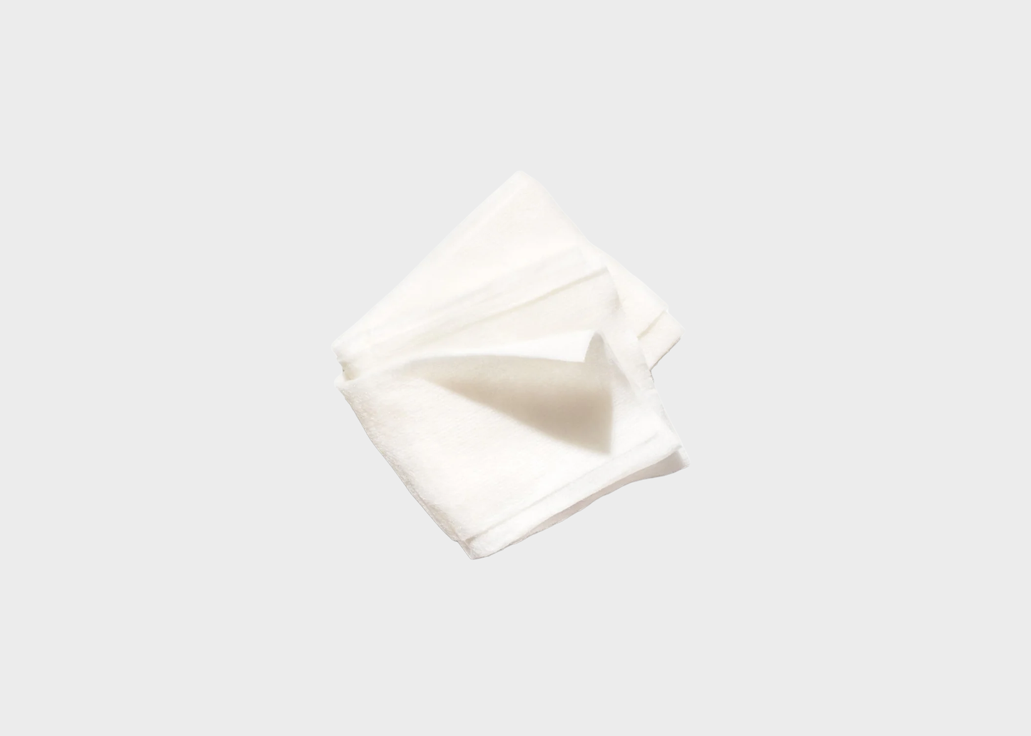 
                  
                    A folded white cotton handkerchief or napkin, shown against a solid light gray background.
                  
                