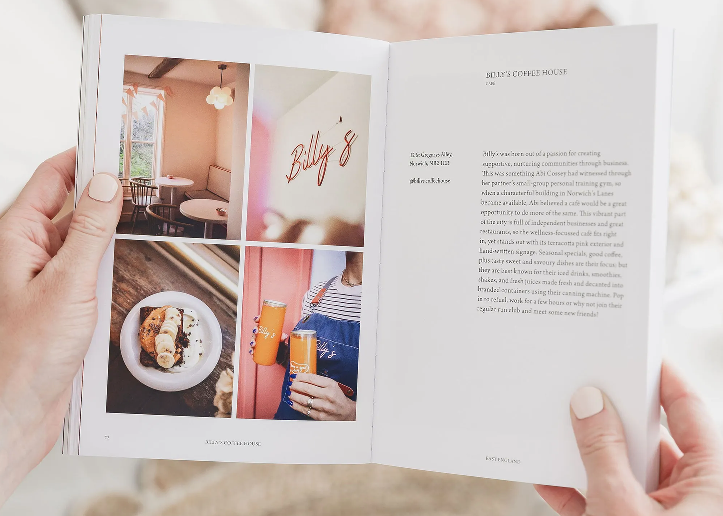 
                  
                    A person holding a book. The left page shows a four-photo collage of a restaurant interior, a plated food dish, and a person holding orange drinks, with the heading 'BILLY'S CAFE & COFFEE HOUSE.
                  
                