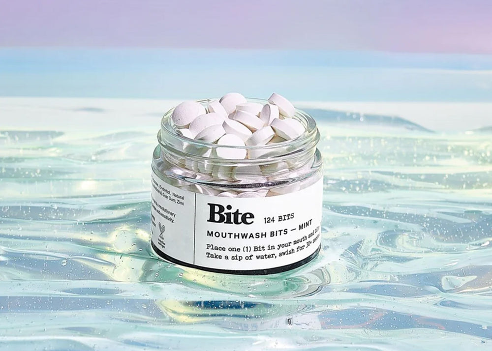 A jar full of white mouthwash mint bits by Bite floating in gel.