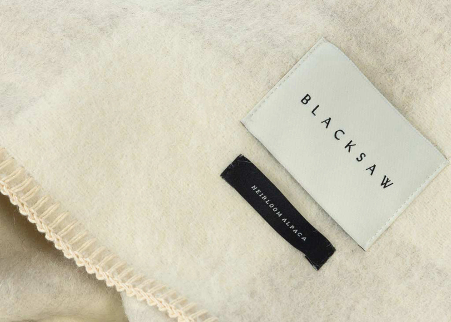 
                  
                    A close up of the tag on a Crosby Heirloom Blanket Shoji/Ivory by Blacksaw as sold by Woodland Mod
                  
                