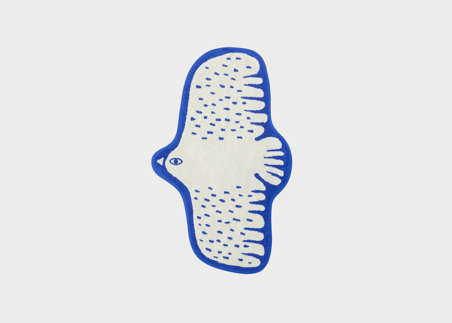 
                  
                    A stylized bird-shaped rug or mat in cream with a blue border and blue dotted wing patterns, centered on a light gray background.
                  
                