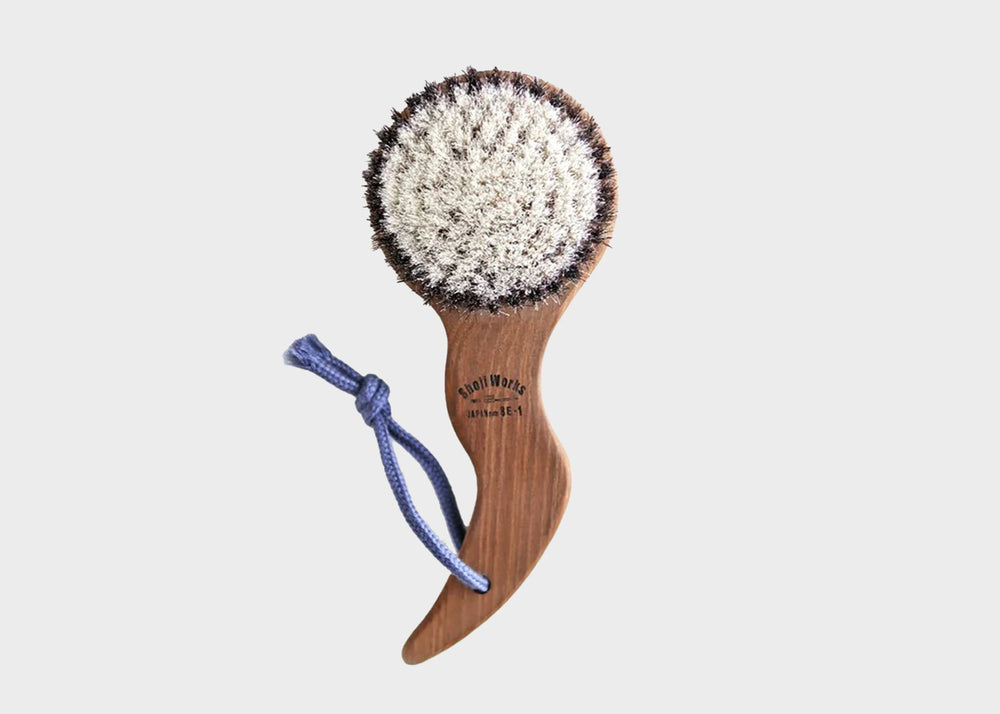 Shoji Works hand held short body brush in a dark wood color with a blue rope string as sold by Woodland Mod