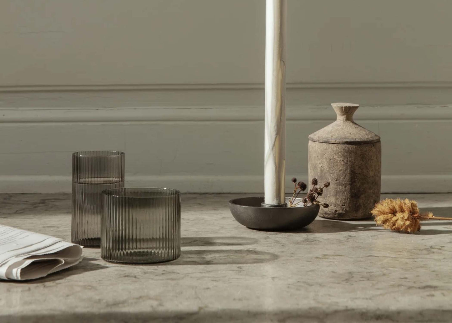 
                  
                    Grey Smoked Low Ripple Glasses by Ferm Living on a table setting
                  
                