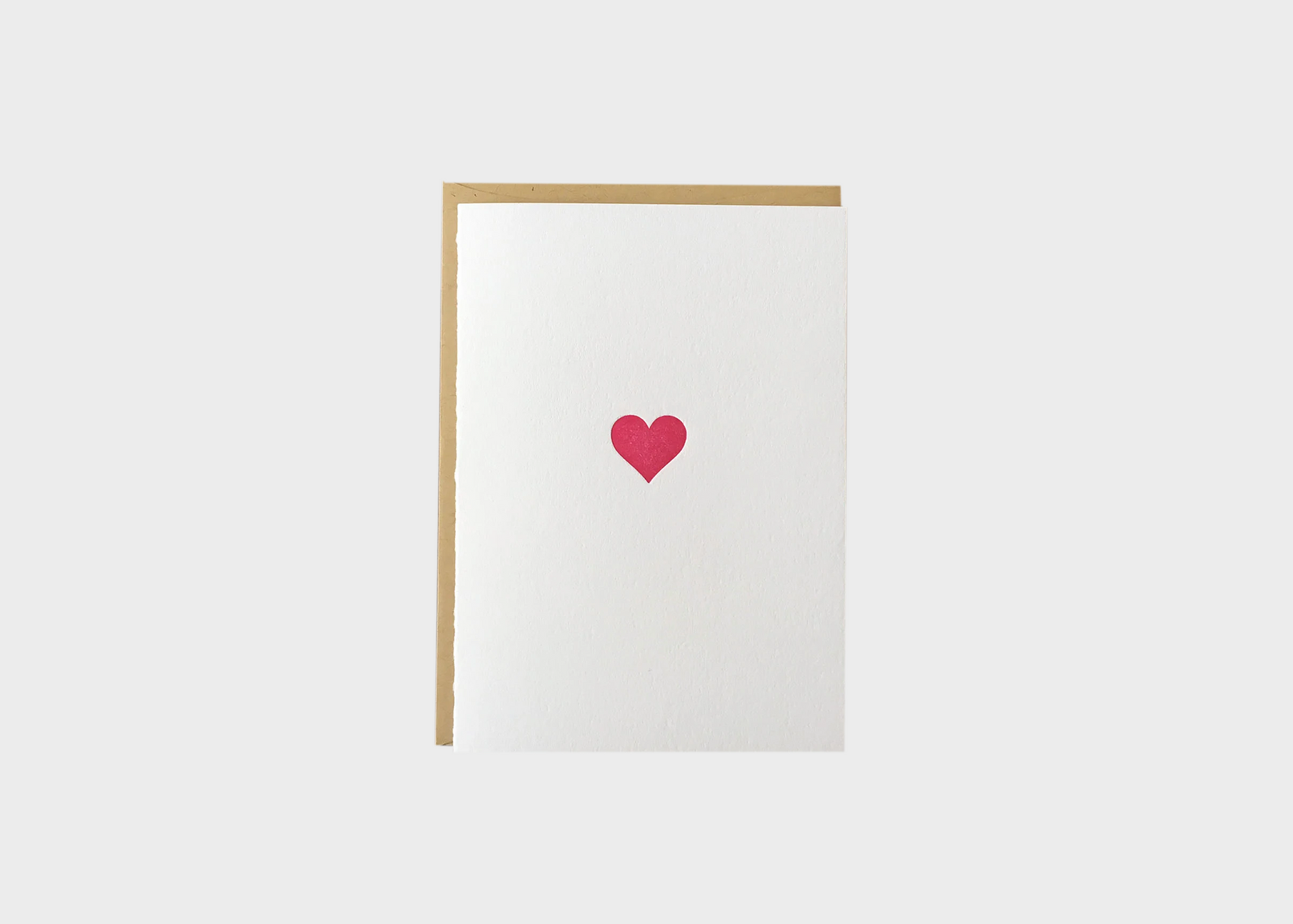 A blank card with a pink heart on the front