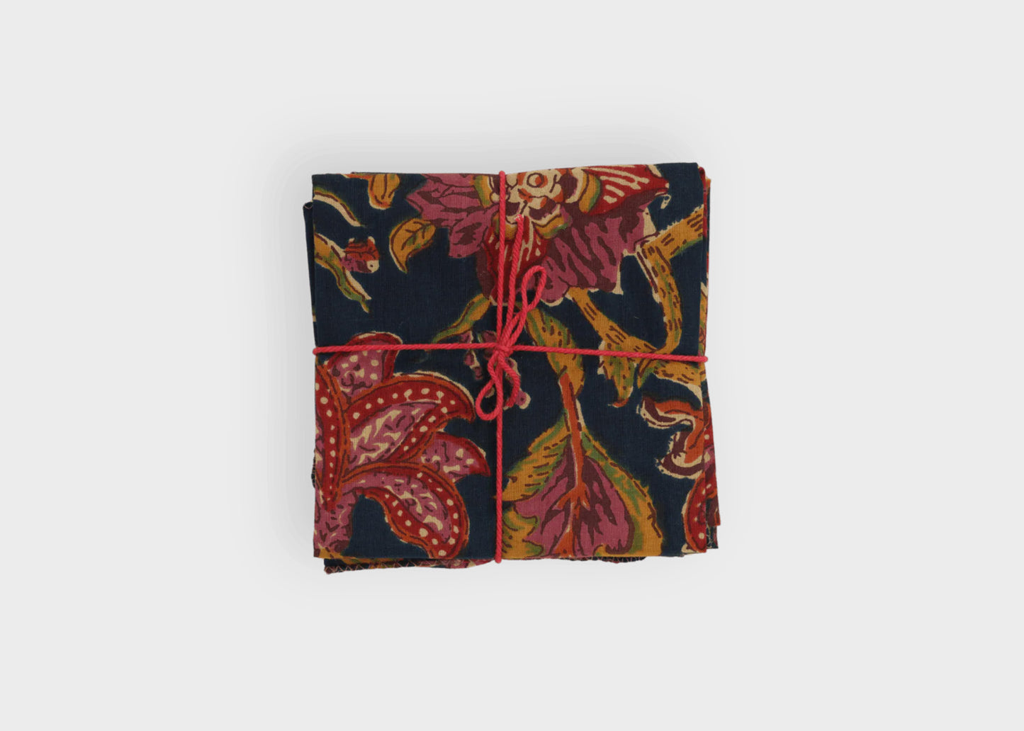 
                  
                    Folded fabric with a floral pattern tied with red string Hysope Patriot napkins Suzette A Table
                  
                