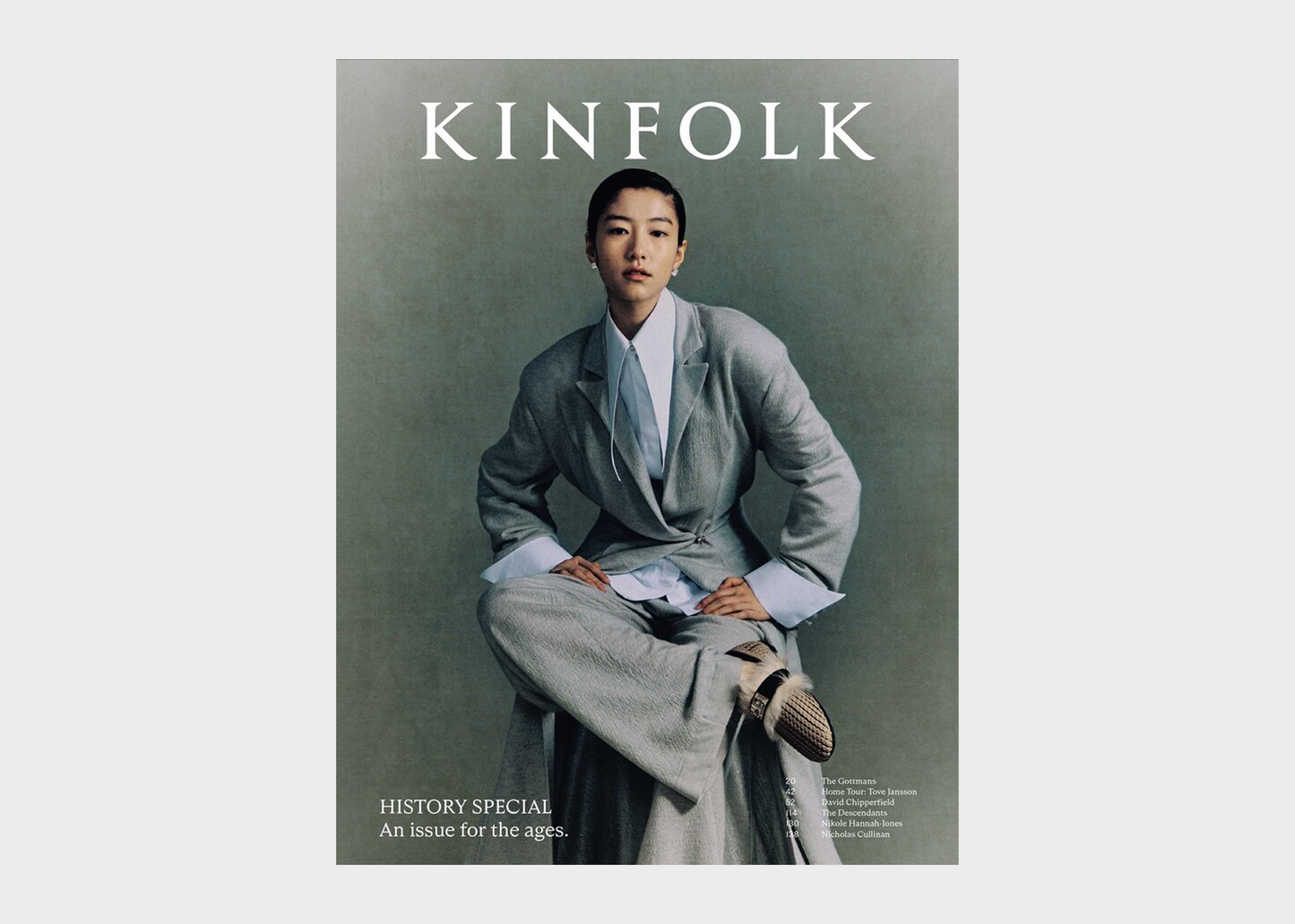 Magazine cover with a person in a gray suit sitting on a stool, featuring the 'KINFOLK' brand.