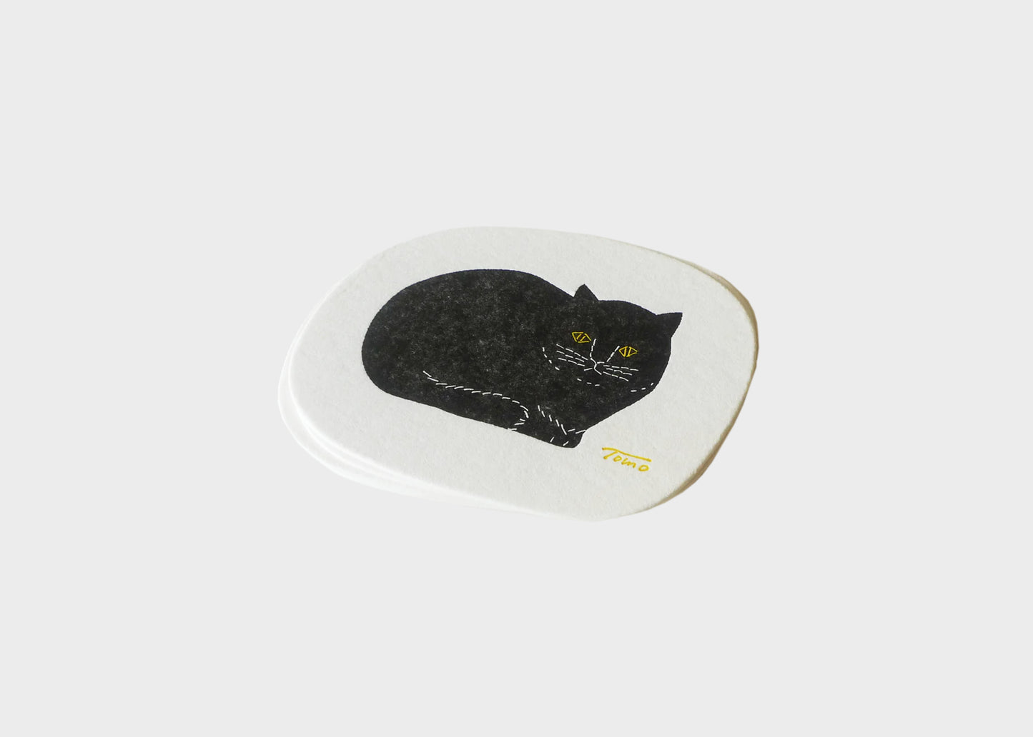 
                  
                    An oval letterpress cat coaster with a white border and a black cat in the middle.
                  
                