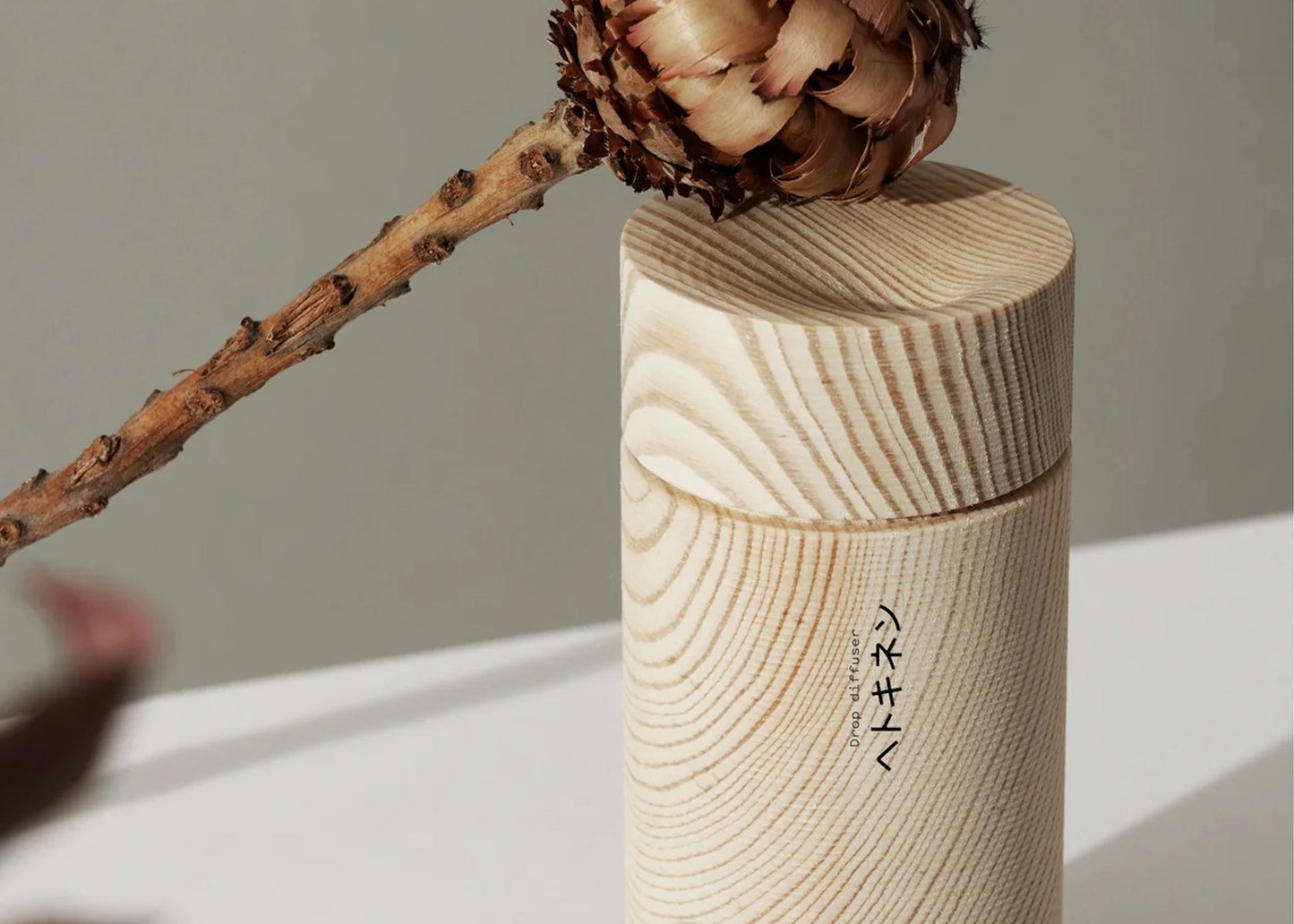 Hetkinen's Tall Drop Diffuser as sold by Woodland Mod next to a flower resting on a lid