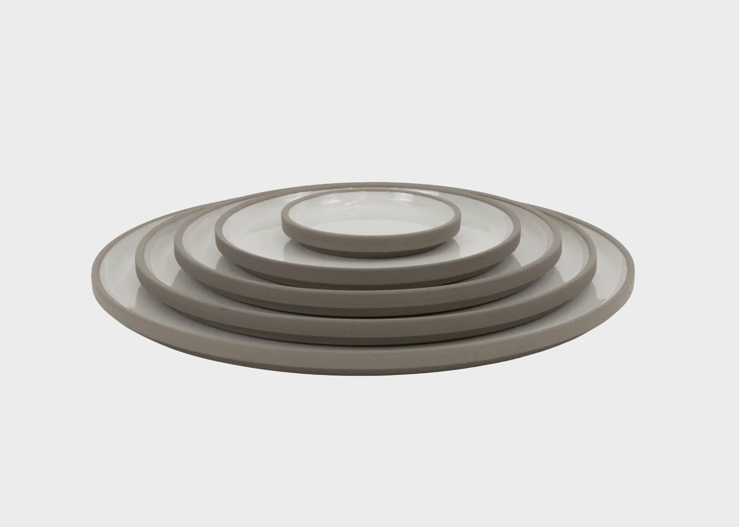 
                  
                    Set of gray ceramic plates stacked on a white background
                  
                