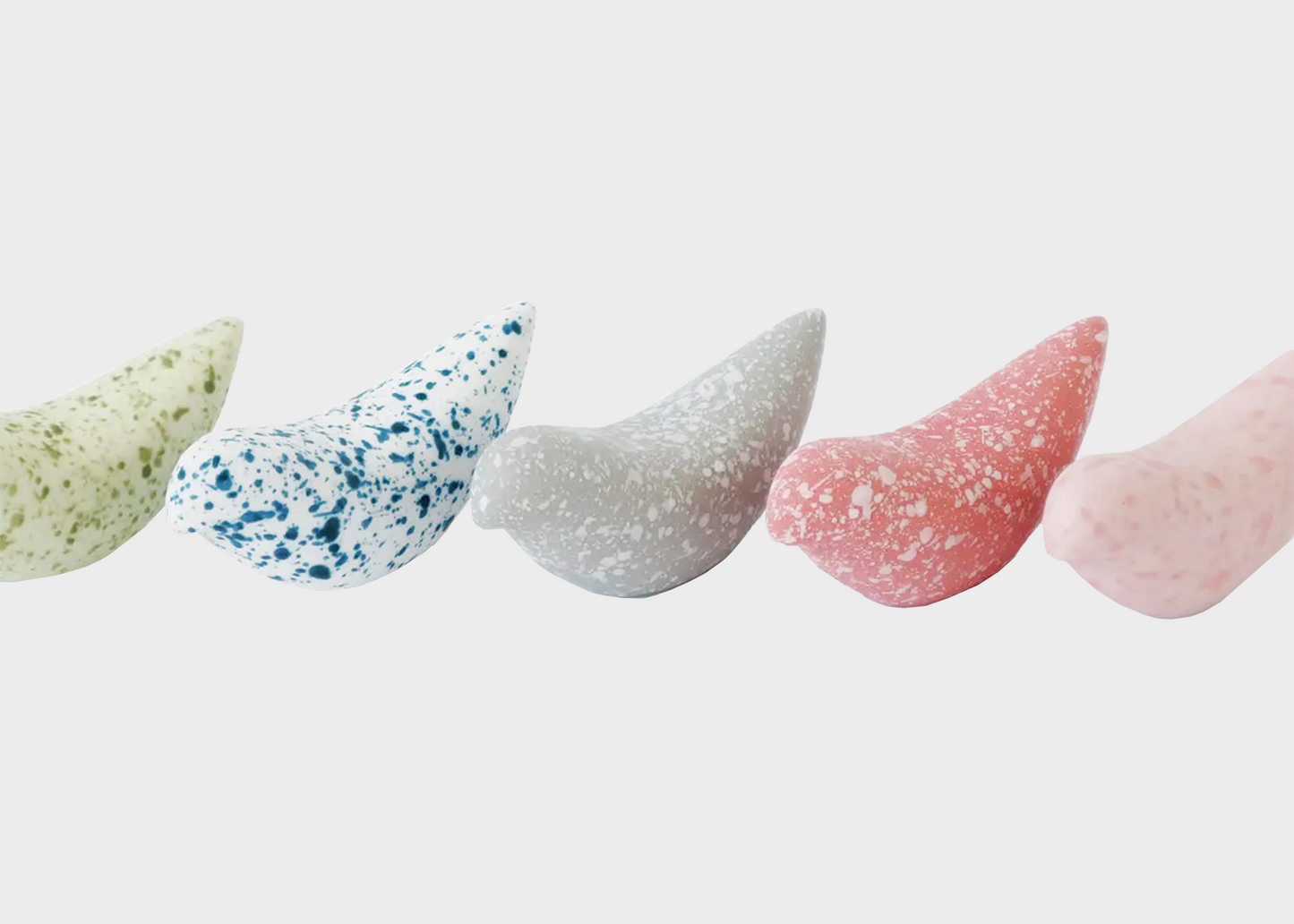 Five colorful bird-shaped chopstick holders on a white background