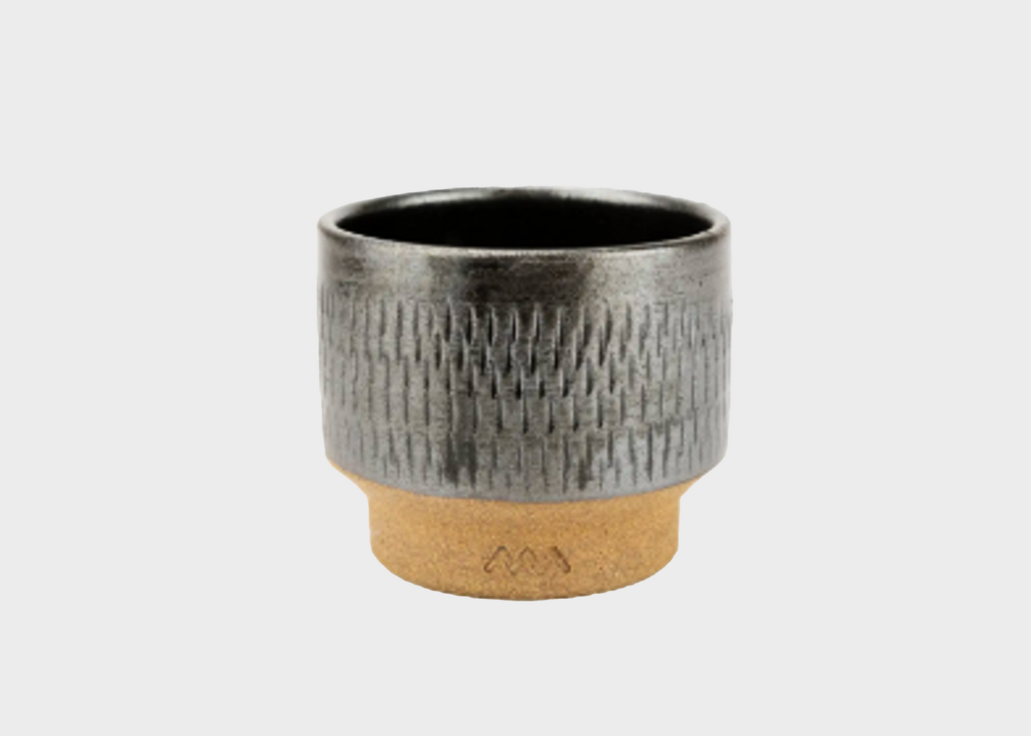 Black textured ceramic cup with a raw base