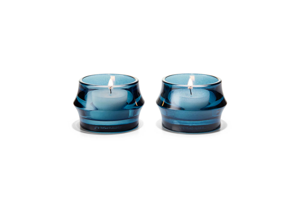 
                  
                    Two blue candles in glass holders on a white background
                  
                
