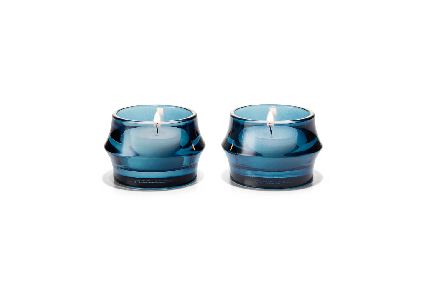 
                  
                    Two blue candles in glass holders on a white background
                  
                