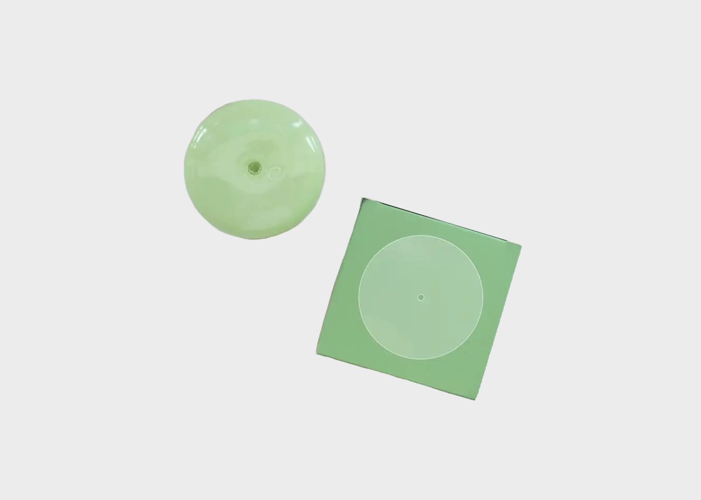
                  
                    Two green incense holders on a light gray background
                  
                