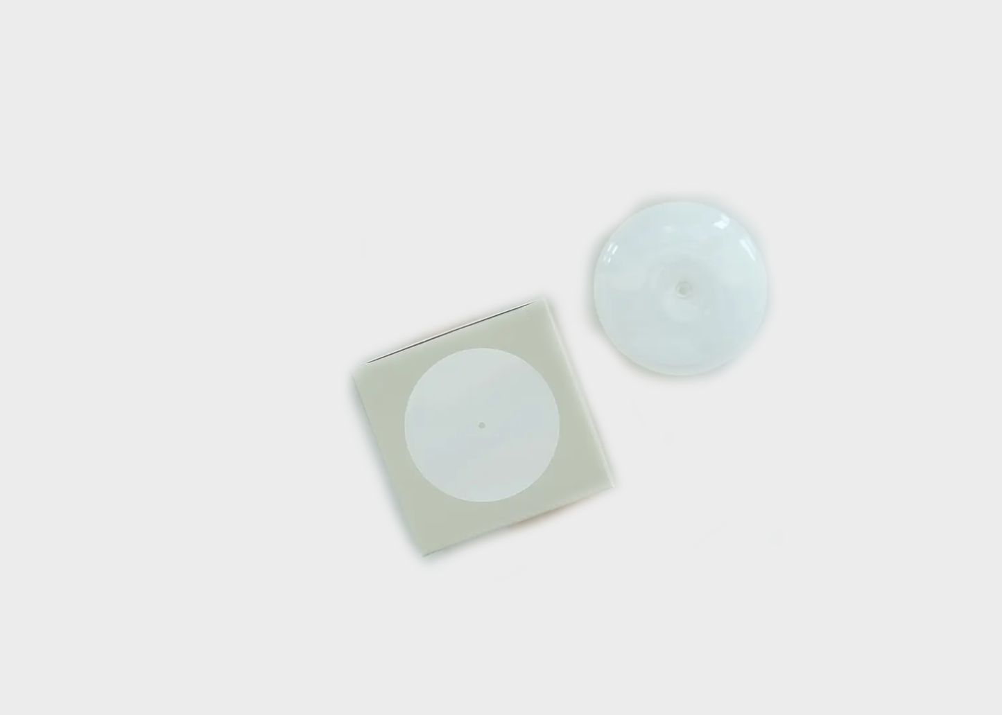 
                  
                    Two round, light-colored incense holders on a white background
                  
                