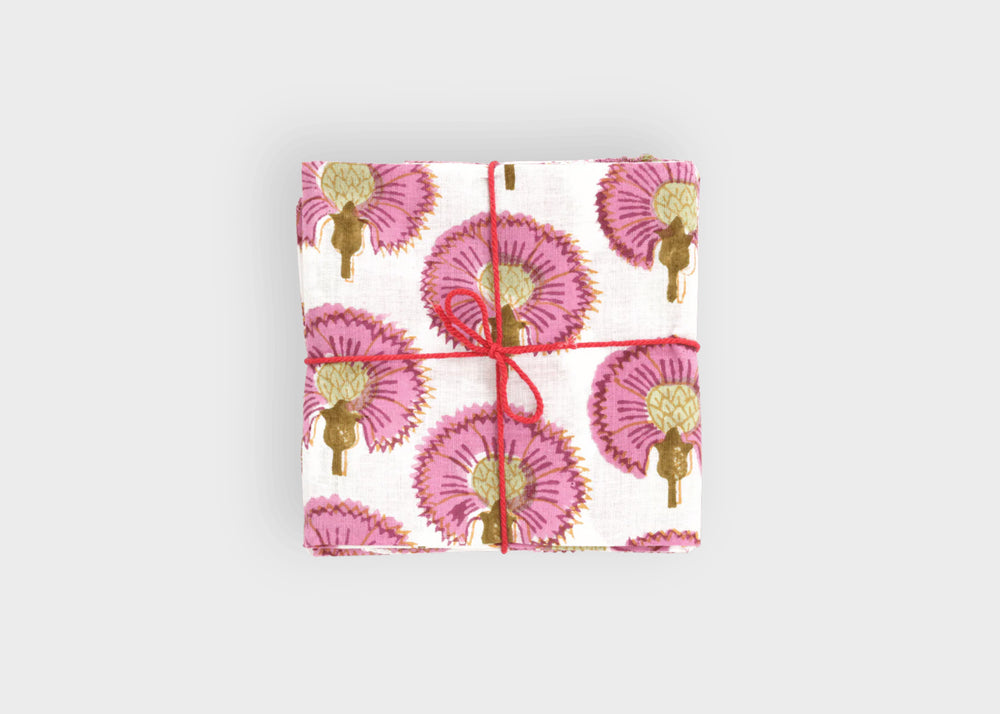 
                  
                    Gift wrapped in pink floral patterned paper with red ribbon on a light gray background cosmos napkins set suzette a table
                  
                