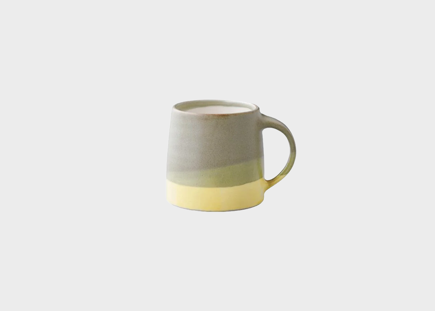 
                  
                    Two-tone ceramic mug with a gradient from beige to yellow on a white background
                  
                