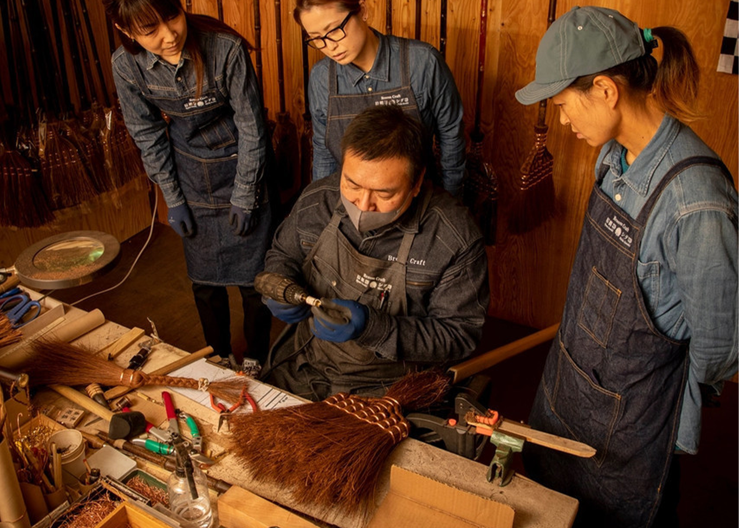 Four people in a workshop setting, working on a project together.