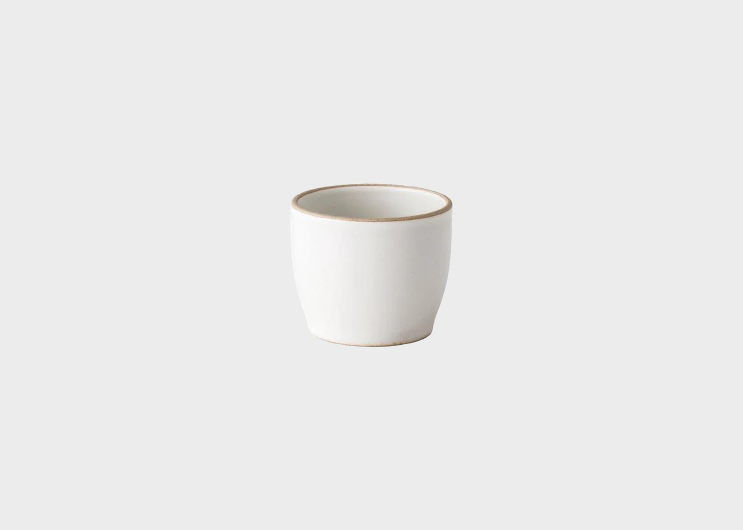 White ceramic cup with natural rim on a light gray background