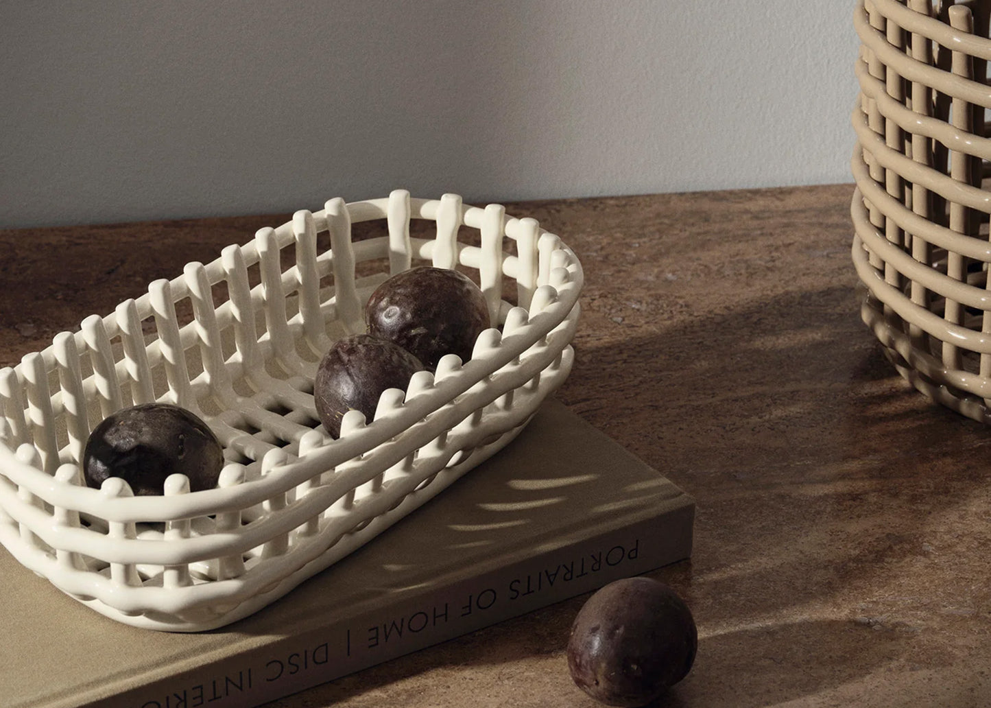 Oval Ceramic Basket Off-White by Ferm Living with fruit inside.
