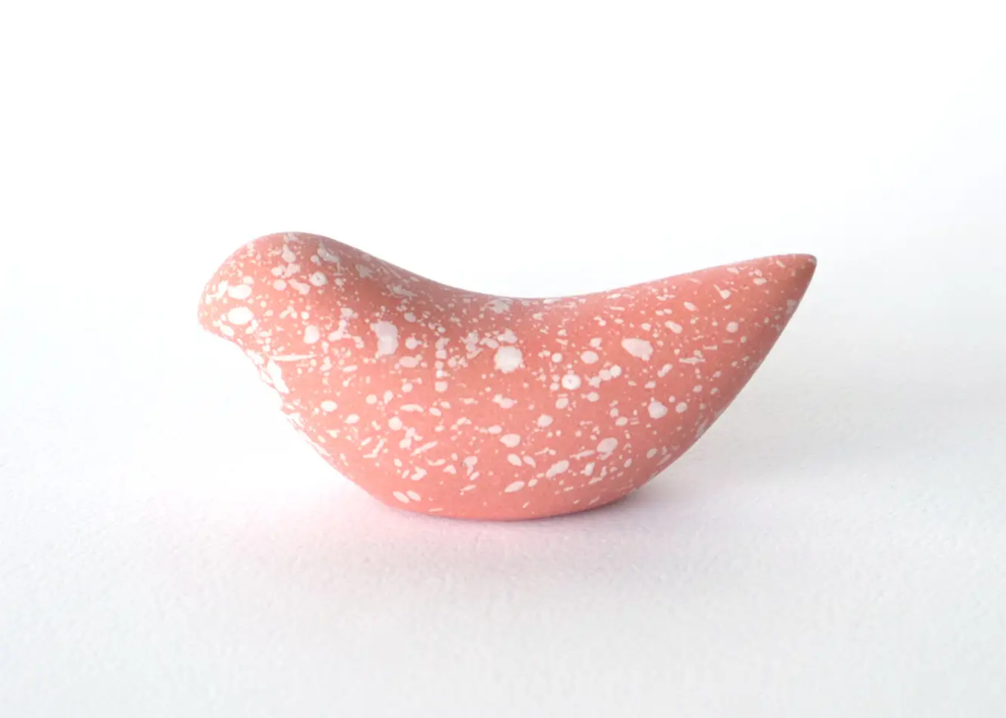 
                  
                    Pink ceramic bird-shaped object on a white background
                  
                