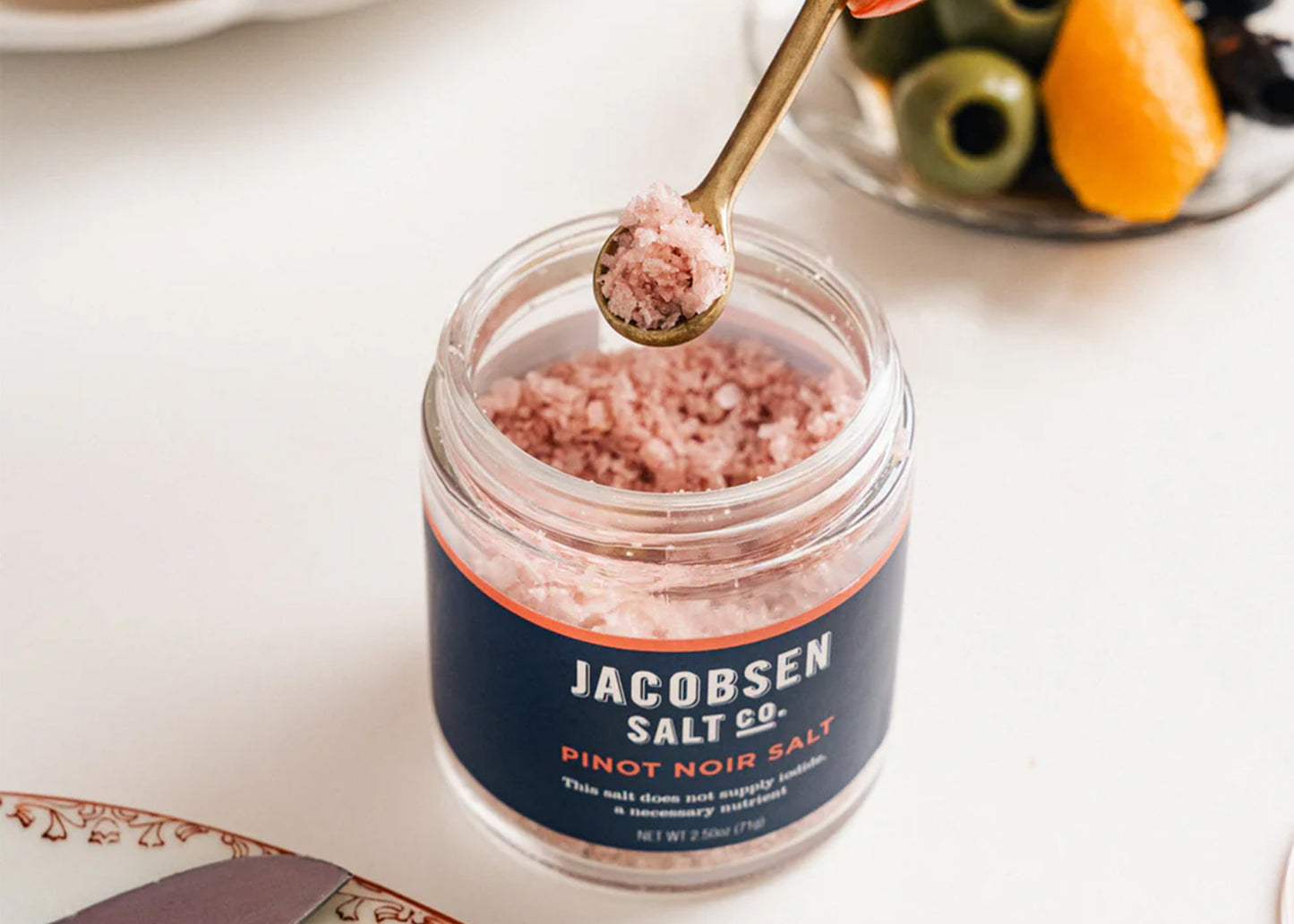 
                  
                    Jar of Jacobsen Salt Co. Pinot Noir salt with a spoonful on a white surface
                  
                