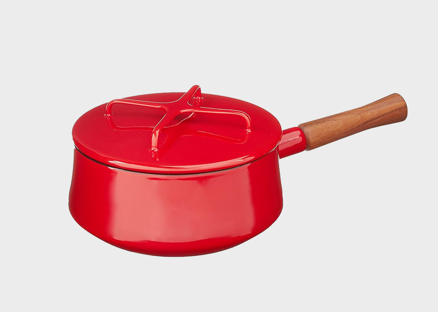 Red enameled cast iron Dansk pot with wooden handle on a light gray background
