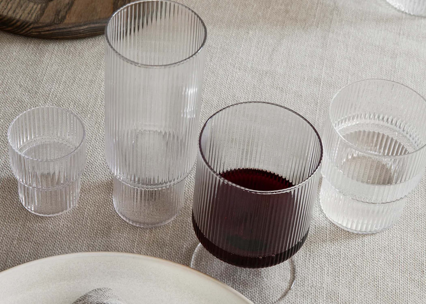 
                  
                    A collection of ripple glasses by Ferm Living on a table
                  
                