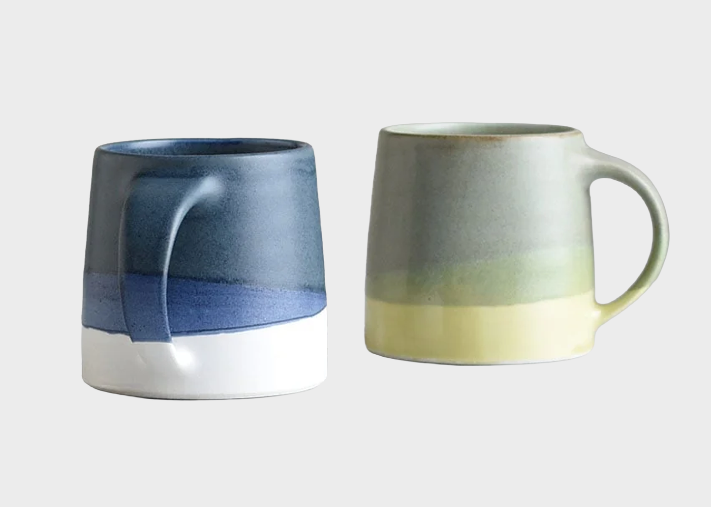 
                  
                    Two ceramic mugs with gradient colors on a light gray background
                  
                