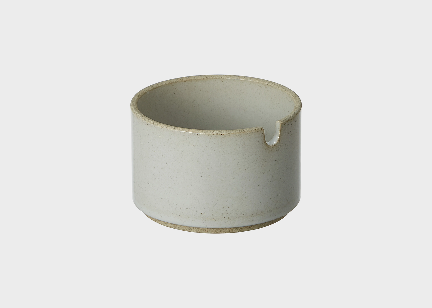 Ceramic sugar cup with a small indent on a light gray background