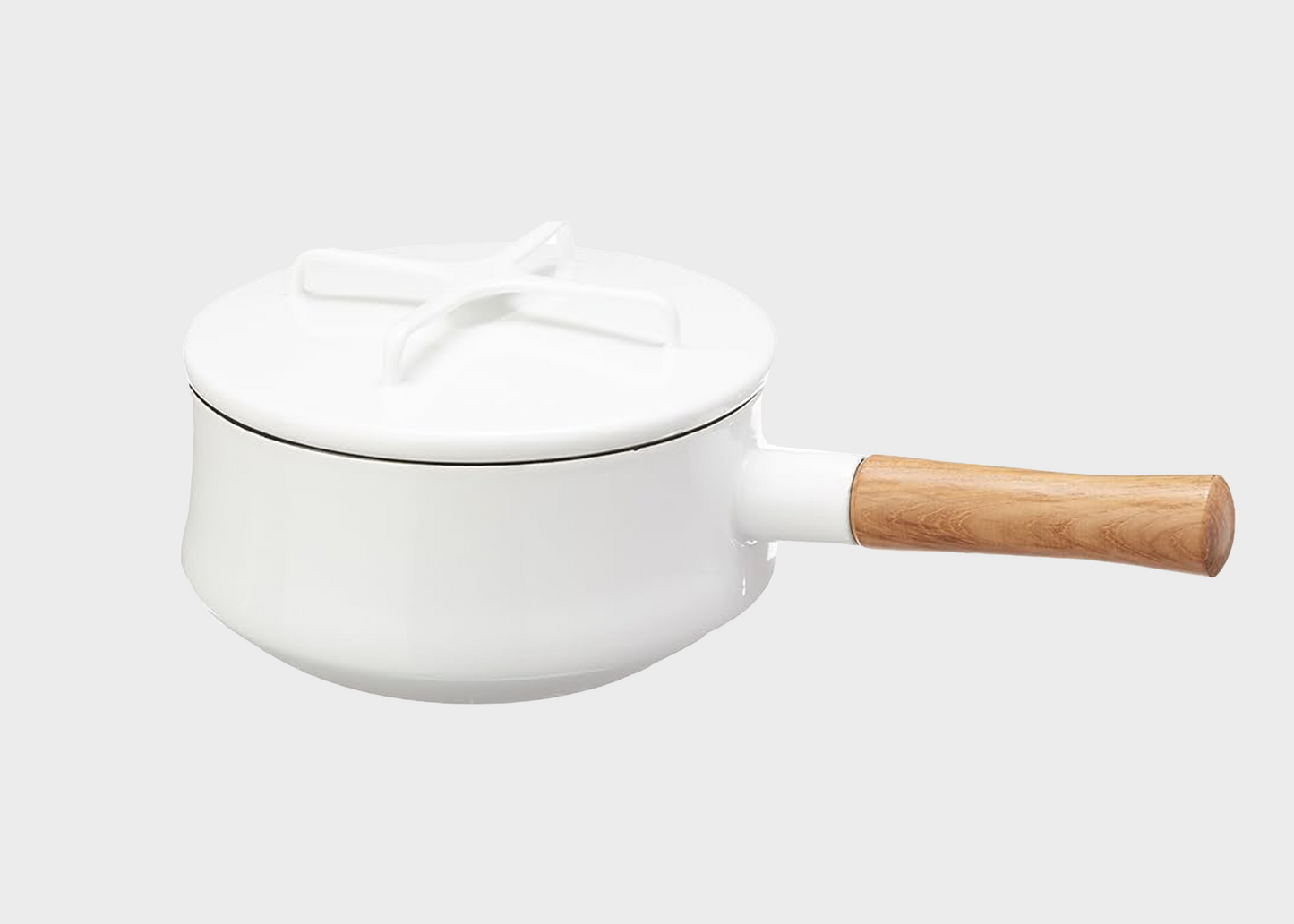 White Dansk Kobenstyle saucepan with a wooden handle on a light gray background