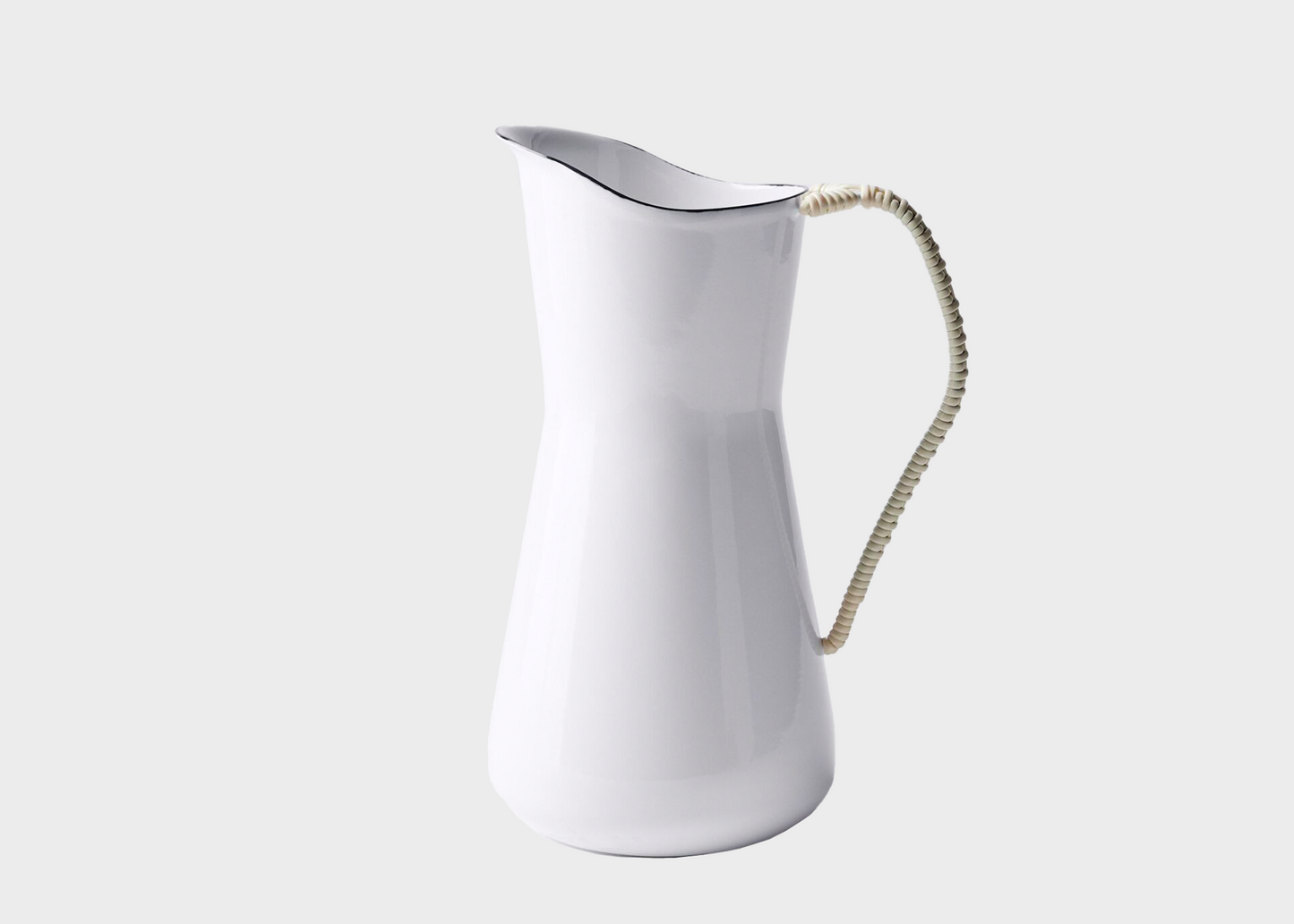 White enamel pitcher with a decorative handle on a light gray background