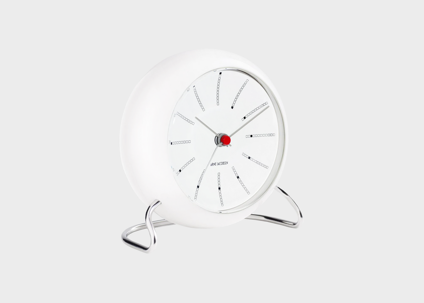 A white banker's alarm clock by designer Arne Jacobsen tilted to the side