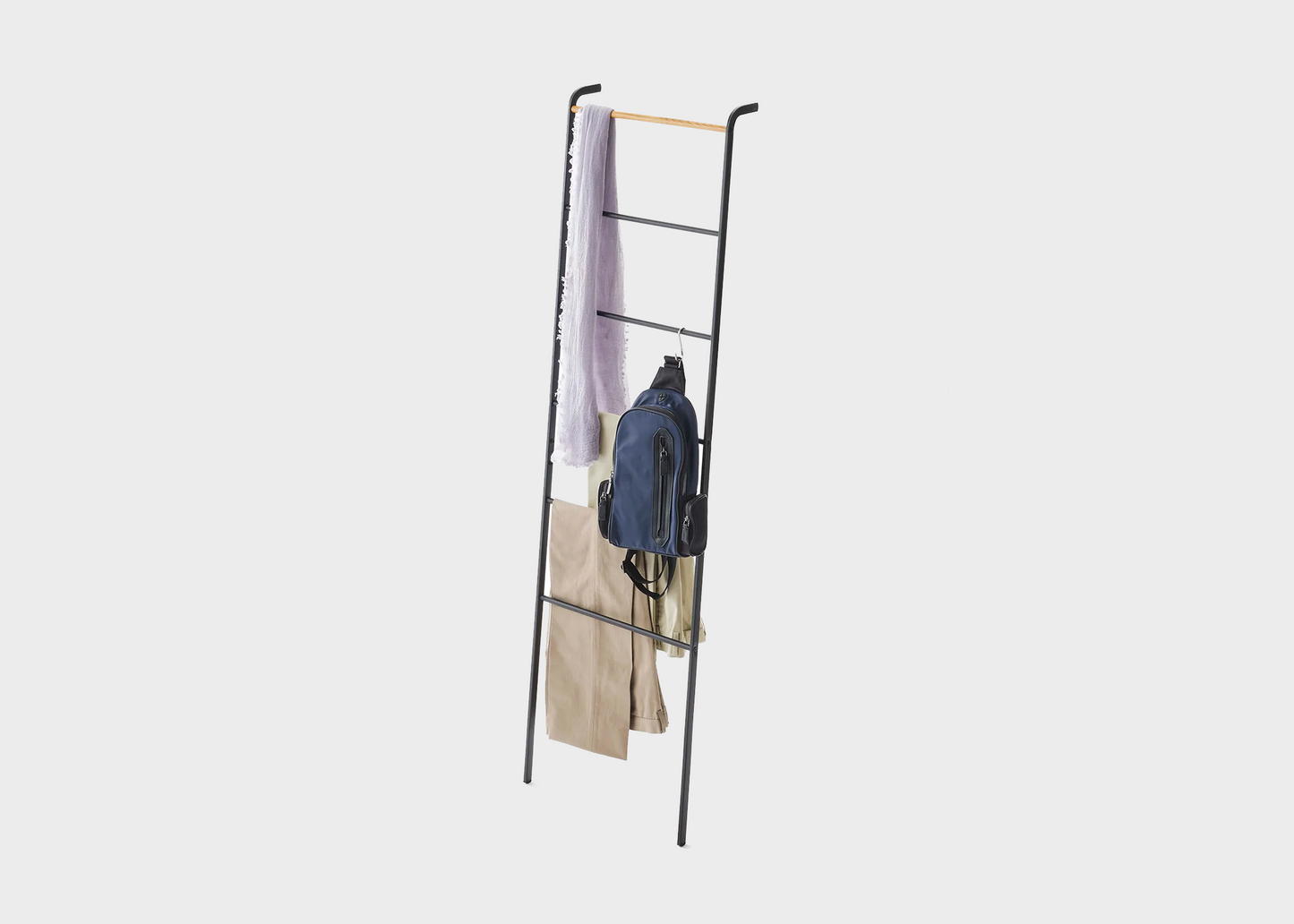 Blanket Ladder - Black by Yamazaki with clothing hanging from it
