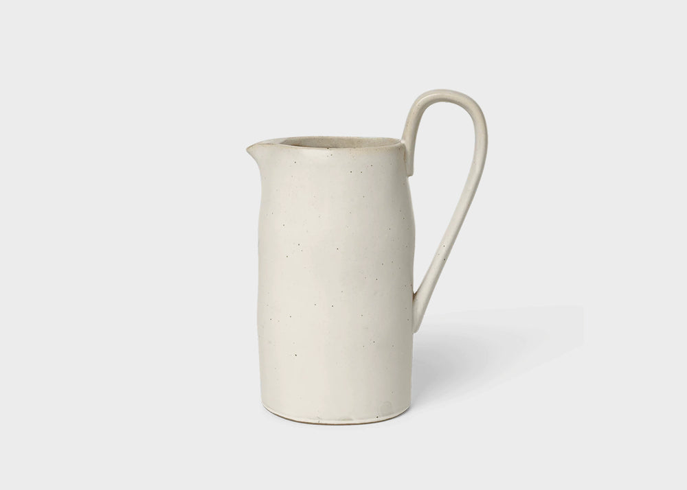 A cream white flow jug by Ferm Living with a round handle