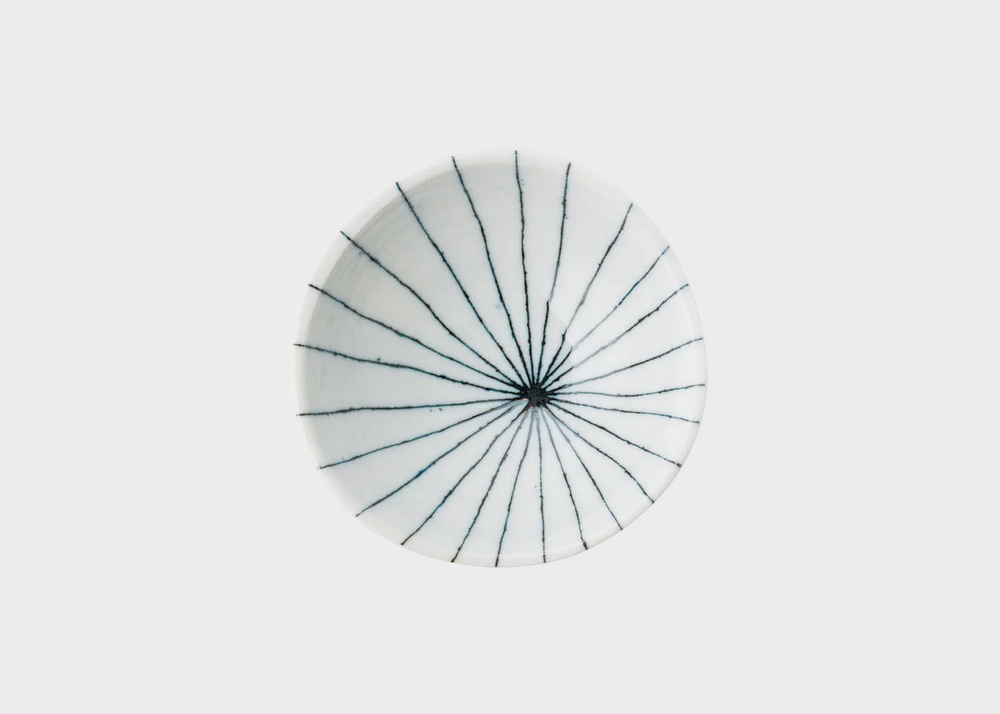 
                  
                    The top view of a small white dipping dish with thin blue lines coming from the center of the dish
                  
                