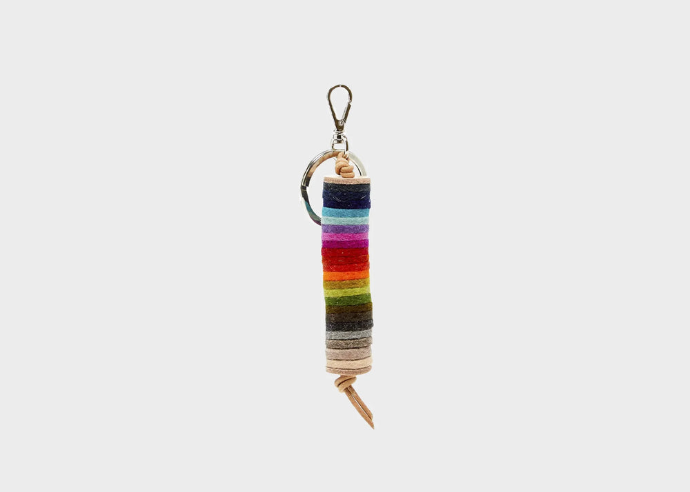 A rainbow colored key fob with leather straps and a silver ring