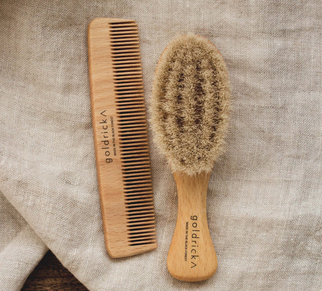A wooden hairbrush and comb intended for toddlers and babies by Goldrick on a blanket