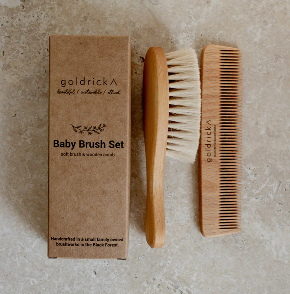 A wooden hairbrush and comb intended for toddlers and babies by goldrick next to packaging box