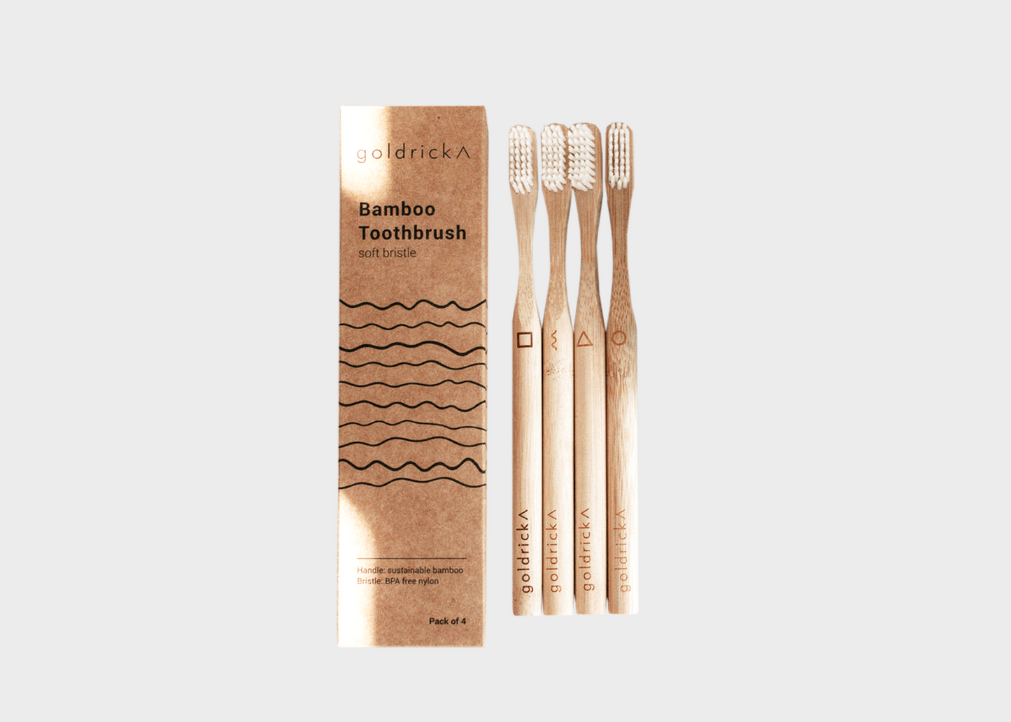 Bamboo toothbrush set next to box by Goldrick