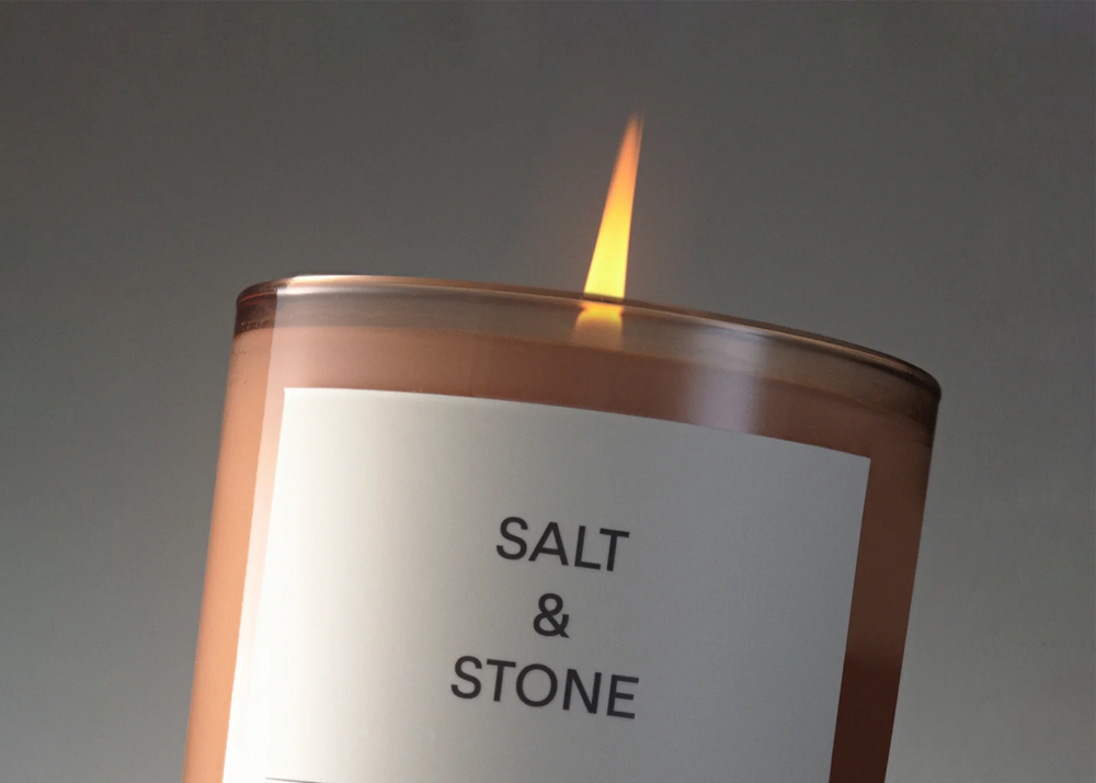 
                  
                    Black Rose & Vetiver Candle by Salt and Stone with pink glass and lit flame
                  
                