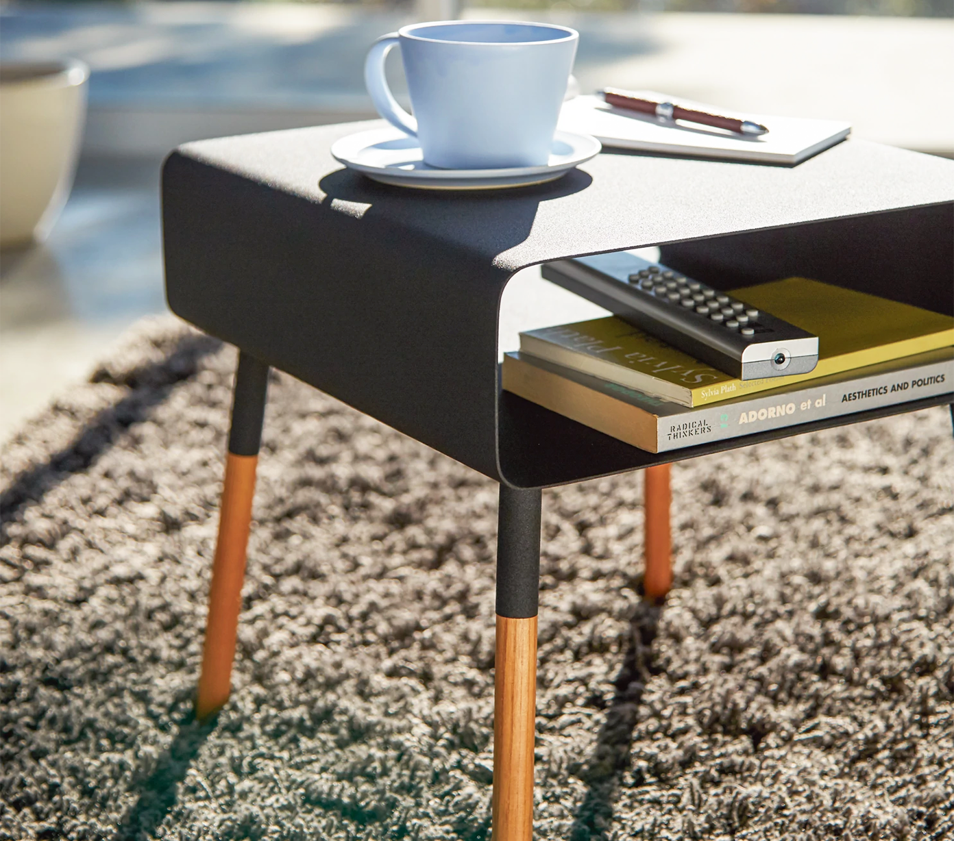 
                  
                    Short Storage Table in black by Yamazaki with a coffee cup and books resting on the surface
                  
                