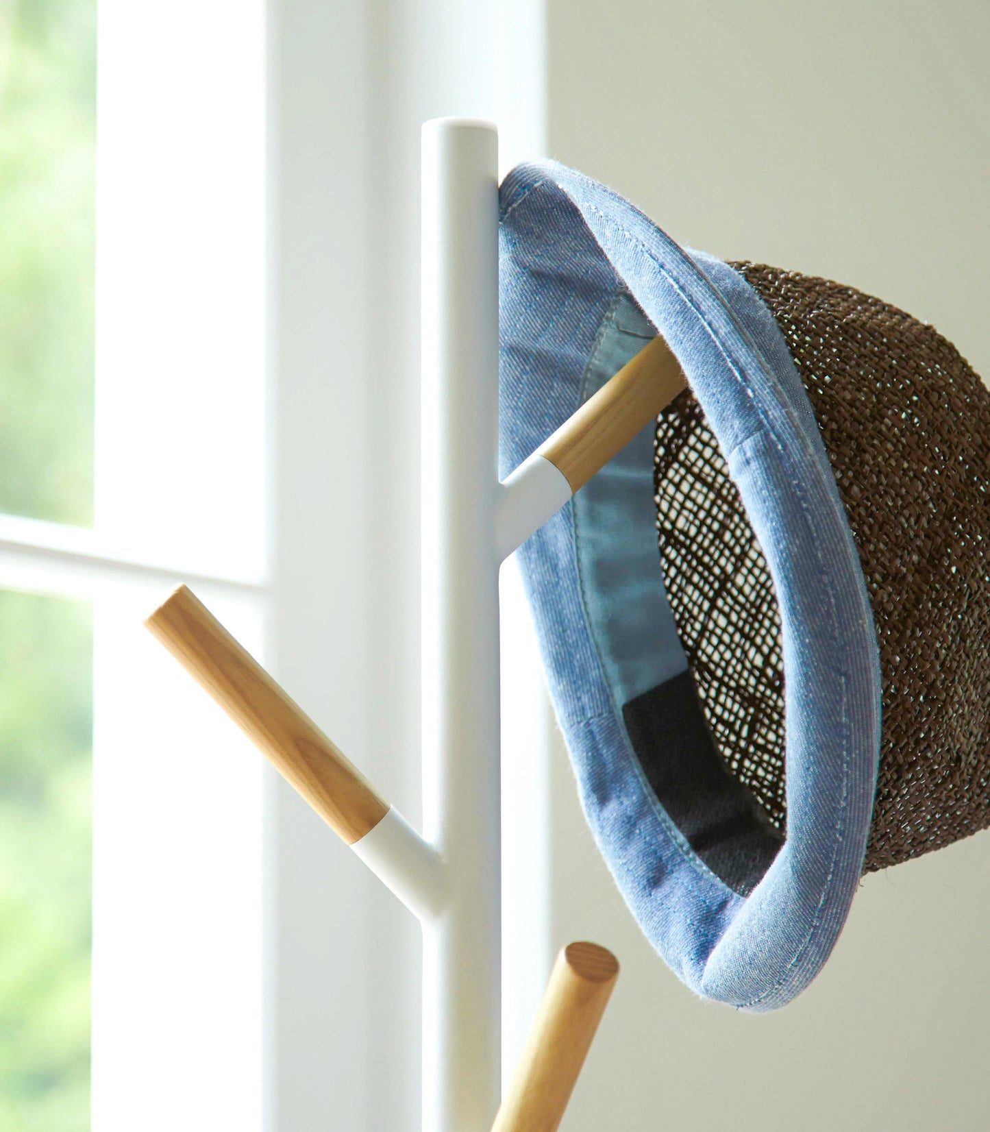 Wood Branch Steel Coat Rack in white by Yamazaki with a hat resting on the peg