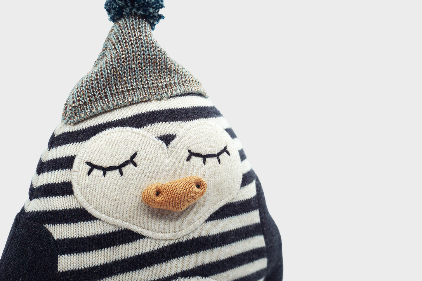 Small striped penguin stuffed animal with hat close up