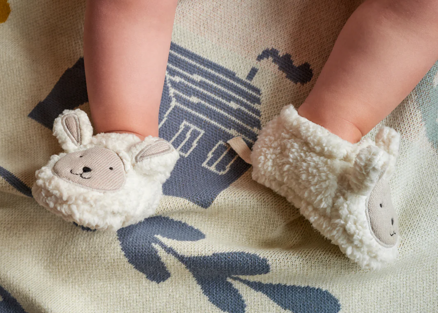 Sheep shaped baby booties on the feet of an infant